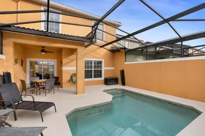 a swimming pool with a patio and a house at 8883 Candy Palm in Kissimmee