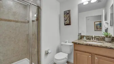 a bathroom with a shower and a toilet and a sink at 8967 Cat Palm in Kissimmee
