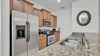 a kitchen with a stainless steel refrigerator and a sink at 8967 Cat Palm in Kissimmee