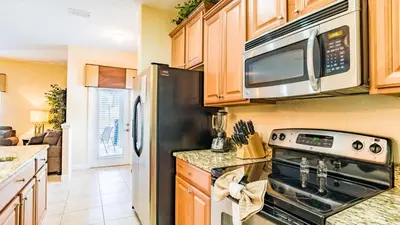 a kitchen with a stove and a microwave at 8951 Coco Palm in Kissimmee