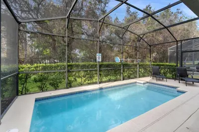 a swimming pool in a glass house with a pergola at 8949 Cuban Palm in Kissimmee
