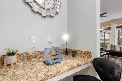 a room with a counter with a clock on the wall at 8949 Cuban Palm in Kissimmee