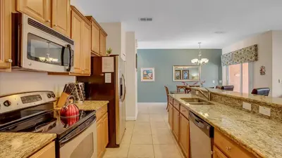a kitchen with a stove and a microwave at 8968 Cuban Palm in Kissimmee