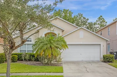 a house with a palm tree and a garage at 201 Hideaway beach 4 beds - pool&spa in Kissimmee