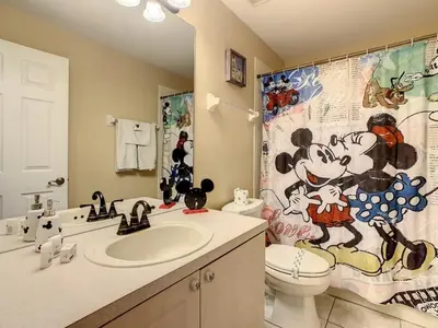 a bathroom with a sink and a toilet and a shower curtain at Beautiful Windsor Palms 4 Bed South Facing Pool villa in Kissimmee