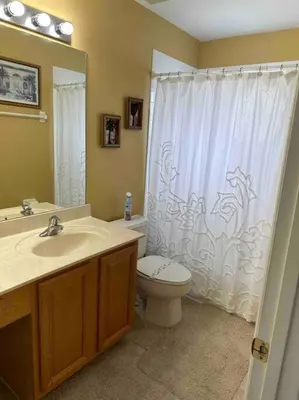a bathroom with a white shower curtain and a toilet at Villa Madiera 6 bedroom huge house in Kissimmee