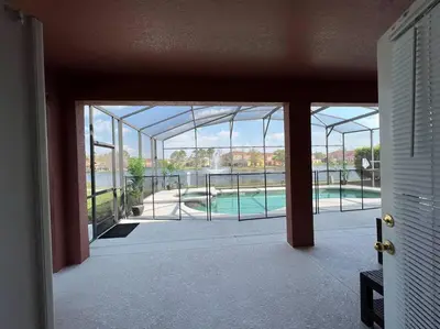 an open door of a house with a view of a pool at Villa Madiera 6 bedroom huge house in Kissimmee