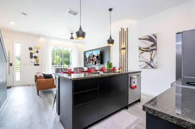 a kitchen with a black island in the middle at Marvelous 3Bd Close to Disney w GameRoom at The Hub 3409 in Kissimmee