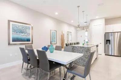 a kitchen and dining room with a white table and chairs at Gorgeous Dream Villa 5 min to Disney in Orlando