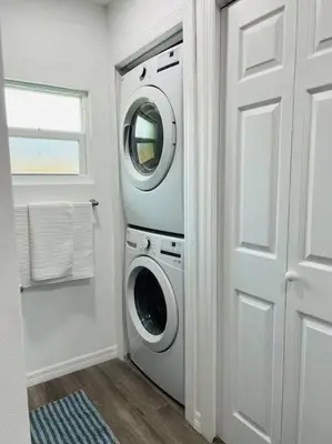 a washer and dryer in a room with a door at Roy's guest house in Orlando