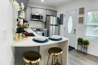 a kitchen with a counter with two stools at Roy's guest house in Orlando