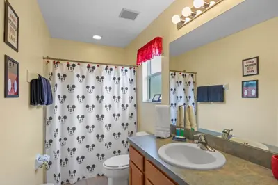 a bathroom with a sink and a shower curtain at Be-Our-Guest Home! 15 mins to Disney! in Kissimmee