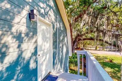 a blue house with a white door and a tree at Dog-Friendly Apt with Fenced Yard in Winter Park in Orlando