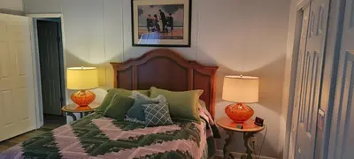 a bedroom with a bed with two lamps on tables at Sanford Country Escape Fire Pit, Yard and Wildlife! in Sanford