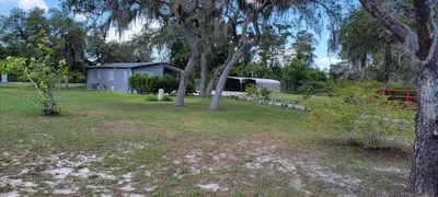 a yard with trees and a shed in the background at Sanford Country Escape Fire Pit, Yard and Wildlife! in Sanford