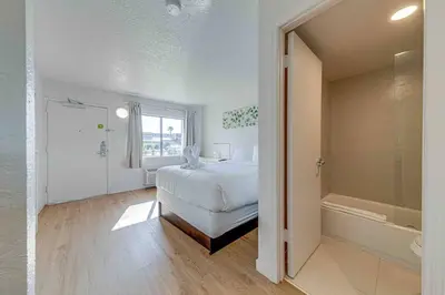 a bedroom with a bed and a tub in a room at Travel Lodge by Wyndham 10 min from Disney in Kissimmee