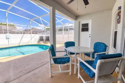 a patio with a table and chairs next to a swimming pool at Clear Creek 3 Bedroom Home Private Pool 15 Min to Disney in Orlando