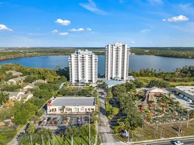 an aerial view of two tall white buildings next to a lake at 2BR condo minutes to Disney Springs in Orlando