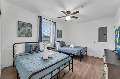 a bedroom with two beds and a ceiling fan at 2BR condo minutes to Disney Springs in Orlando