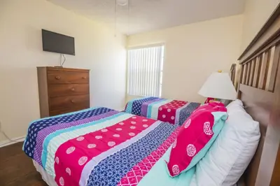 a bedroom with two beds and a dresser at Sweetwater Club 3 Bedroom Condo Resort Pool 9 Miles to Disney in Kissimmee