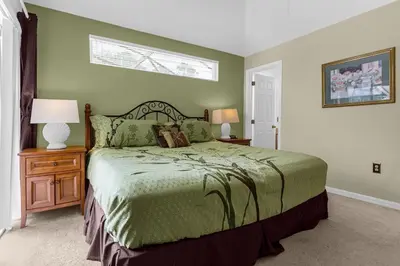 a bedroom with a bed and two lamps and a window at 1061 Lake Berkley 4 Bed with Pool&Spa in Kissimmee