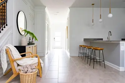 a kitchen with white walls and a counter and stools at Luxurious Home w Theme Beds & Private Pool in Kissimmee