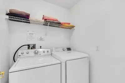 a laundry room with two washing machines and a drying rack at 4 bedrooms pool home with water view and short drive from Disney in Kissimmee