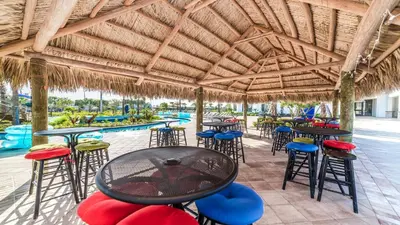 a patio with tables and chairs and a swimming pool at Storey Lake 6BR Cozy Home Private Pool Near Disney in Kissimmee