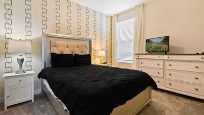 a bedroom with a large bed and a dresser at Storey Lake 6BR Cozy Home Private Pool Near Disney in Kissimmee
