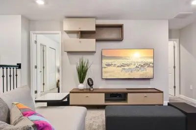 a living room with a couch and a tv on a wall at Storey Lake 10BR Lakeview Home Pool/SPA Game Room in Kissimmee