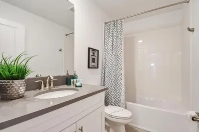a bathroom with a sink and a toilet and a tub at Storey Lake 10BR Lakeview Home Pool/SPA Game Room in Kissimmee