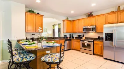 a kitchen with wooden cabinets and stainless steel appliances at Windsor Hills 6br Cozy Home Pool/Spa 2miles Disney in Orlando