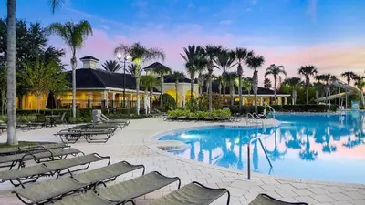a swimming pool with lounge chairs and a resort at 6BR Private Pool, Spa, Gameroom, Close to Disney in Orlando