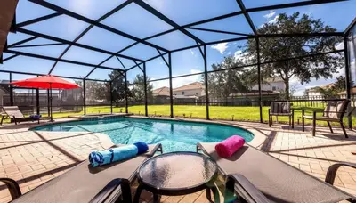 a swimming pool with a glass roof with chairs and a table at 6BR Private Pool, Spa, Gameroom, Close to Disney in Orlando