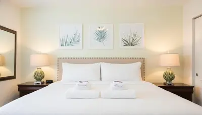 a bedroom with a large white bed with two lamps at 6BR Private Pool, Spa, Gameroom, Close to Disney in Orlando