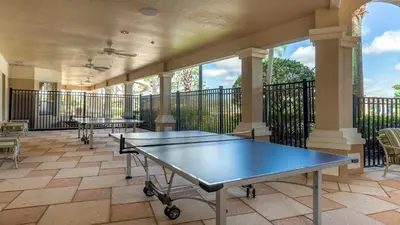 a tennis court with two ping pong tables on a balcony at Windsor Hills 7BR Villa Pool SPA Disney Greenview in Orlando