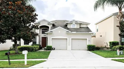 a white house with two garage doors at Windsor Hills 5br Private Pool, Near Disney in Orlando