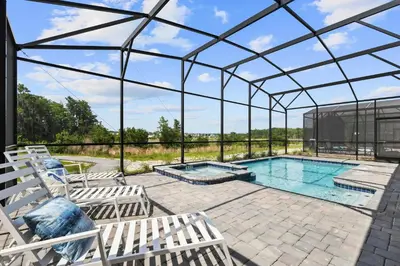 a glass greenhouse with a pool and chairs at Lakeview Villa Near Disney with Pool & Resort in Kissimmee