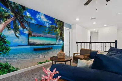 a living room with a blue couch and a large screen tv at Lakeview Villa Near Disney with Pool & Resort in Kissimmee