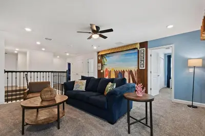 a living room with a blue couch and a ceiling fan at Lakeview Villa Near Disney with Pool & Resort in Kissimmee