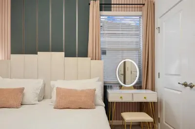 a bedroom with a white bed and a mirror at Lakeview Spacious 12br Themed Home Game/Pool/Spa in Kissimmee
