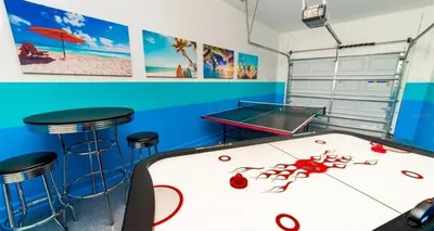 a room with a ping pong table and stools at Lakeview 6BR Cozy Home Pool/SPA,Steps to Waterpark in Kissimmee