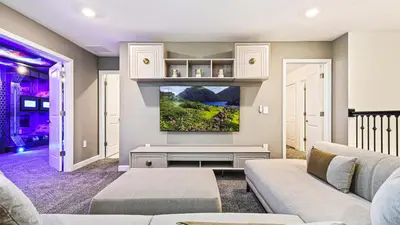 a living room with a couch and a tv at Lakeview 10BR Home Pool/SPA Game Room Disney Theme in Kissimmee