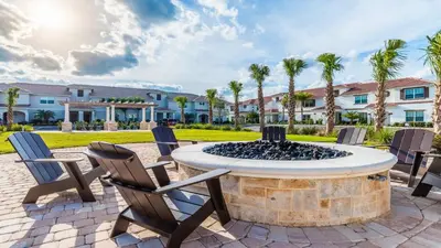 a patio with chairs and a fountain in front of a building at Star Wars Disney Themed 10BR Villa Pool/Spa/Game in Kissimmee