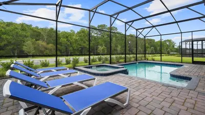 a swimming pool in a glass house with lounge chairs at Star Wars Disney Themed 10BR Villa Pool/Spa/Game in Kissimmee