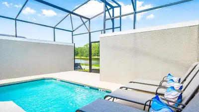 a swimming pool with two chairs next to a swimming pool at Storey Lake 5br Family Townhome w Pool Near Disney in Kissimmee