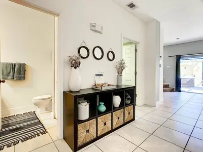 a bathroom with a toilet and a shelf with vases on it at 3 Bedroom Townhome Close to Disney in Kissimmee