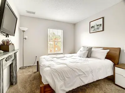 a white bedroom with a bed and a television at 3 Bedroom Townhome Close to Disney in Kissimmee