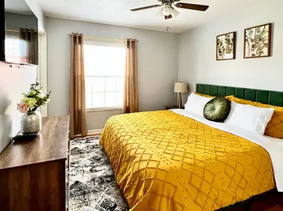 a bedroom with a yellow bed and a window at Stylish 3 bd townhouse near Disney with private pool. in Kissimmee