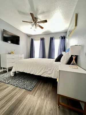 a bedroom with a bed and a ceiling fan at Stylish 3 bd townhouse near Disney with private pool. in Kissimmee